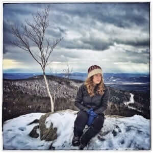 Erica Marcus sits on top of a snowy hill
