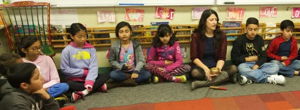 Neena Barreto sits with her students.